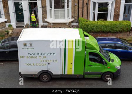 Waitrose van à l'extérieur de la maison dans la zone urbaine avec chauffeur sur le pas de la porte. Banque D'Images