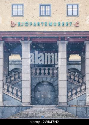 Cette image capture un moment de sérénité hivernale avec des flocons de neige tombant doucement devant le Sjöfartsmuseet, mettant en valeur les colonnes majestueuses des musées et gran Banque D'Images