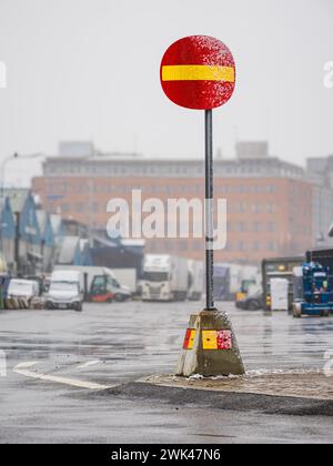 L'image montre un panneau d'interdiction d'entrée rouge et jaune vif sur une rue urbaine humide avec des gouttes de pluie ou de la brume visibles. L'atmosphère brumeuse crée un flou aro Banque D'Images