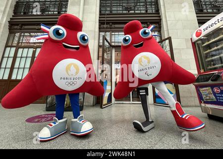 Paris, France. 16 février 2024. Vincent Isore/IP3 ; Paris, France 16 février 2024 - les mascottes des Jeux Olympiques et Paralympiques de Paris 2024 posent devant un magasin officiel vendant des produits des Jeux à la Gare de Lyon. Les mascottes s’appellent Phryges et s’inspirent de la casquette phrygienne, symbole révolutionnaire de la République française et de la liberté. SPORT, MASCOTTES, ILLUSTRATION, JO DE PARIS 2024, MARKETING, PRODUITS DERIVES, COSTUMES DE DEGUISEMENTS, JEUX OLYMPIQUES, MASCOTTE, LES PHRYGES, ECONOMIE, SPORT, crédit : MAXPPP/Alamy Live News Banque D'Images