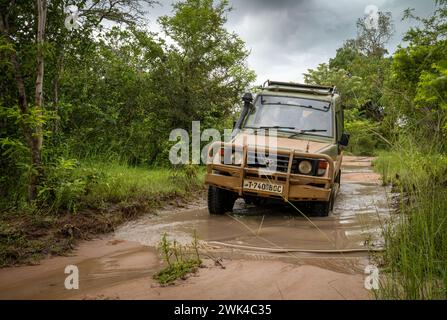 Un véhicule 4x4 roule le long d'une piste inondée lors d'un safari à l'intérieur du parc national de Nyerere (réserve de gibier Selous) en Tanzanie. Banque D'Images