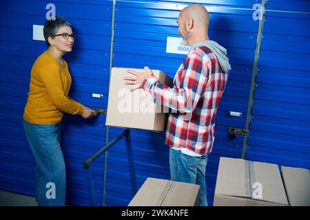 Une femme ouvre la porte tandis qu'un homme se tient à proximité Banque D'Images