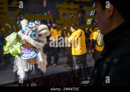 Boston, Massachusetts, États-Unis. 18 février 2024. Un spectateur regarde les danseurs de lion prétendre manger de la laitue verte, qui symbolise la richesse et la bonne chance, à la parade de danse du lion du nouvel an chinois de Boston depuis l'intérieur du Potluck Cafe dans le quartier Chinatown de Boston, Massachusetts, le dimanche 18 février 2024. (Crédit image : © Andrew Burke-Stevenson/ZUMA Press Wire) USAGE ÉDITORIAL SEULEMENT! Non destiné à UN USAGE commercial ! Crédit : ZUMA Press, Inc/Alamy Live News Banque D'Images