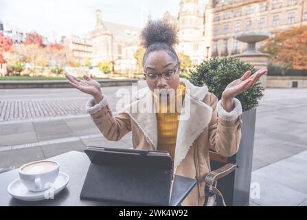 Étudiante africaine femme e-learning formation à distance étude de cours travailler dans un café. Jeune femme ethnique regardant le webinaire d'éducation en ligne à l'aide d'un ordinateur portable. Banque D'Images