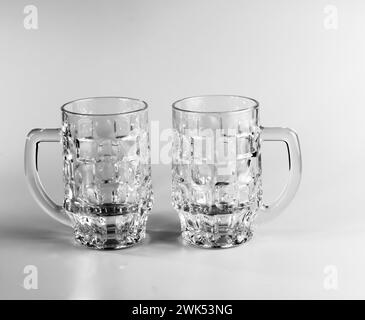 Deux verres à bière vides sur un fond blanc. Tasses à bière en cristal. Banque D'Images