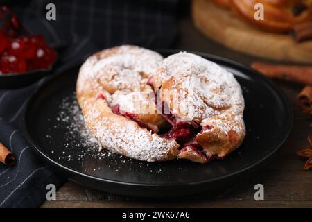 Délicieux petits pains avec des baies et du sucre en poudre sur une table en bois, gros plan Banque D'Images