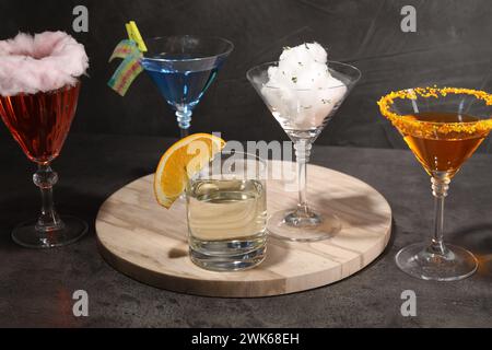 Savoureux cocktail de barbe à papa et autres boissons alcoolisées dans des verres sur une table texturée grise Banque D'Images