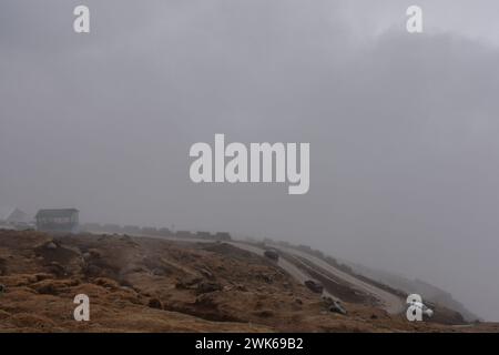 Srinagar, Inde. 18 février 2024. Les véhicules circulent sur la route sous la pluie et le brouillard à la périphérie de Srinagar, la capitale estivale du Jammu-et-Cachemire. Des chutes de neige fraîches ont été signalées dans les parties supérieures du Cachemire, tandis que les plaines ont connu des pluies, entraînant une baisse significative des températures. Le bureau météorologique a prévu des chutes de neige modérées à fortes ou des précipitations dans la vallée du Cachemire pour les trois prochains jours. (Photo de Saqib Majeed/SOPA images/Sipa USA) crédit : Sipa USA/Alamy Live News Banque D'Images