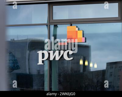 Signe de logo PwC sur une fenêtre en verre d'immeuble de bureaux. Les lettres signifient PricewaterhouseCoopers. La société offre des services de conseil professionnels. Banque D'Images