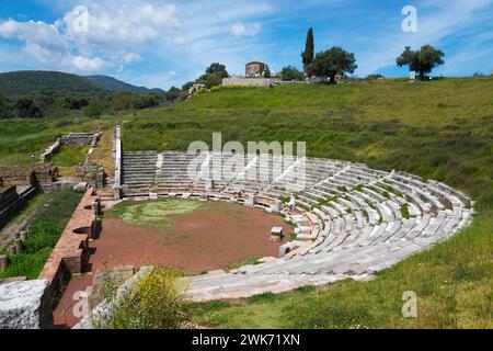 Un théâtre antique avec des marches en pierre entouré de verdure luxuriante et des ruines en arrière-plan, Messène, polis grec antique, Messini, Messénie Banque D'Images