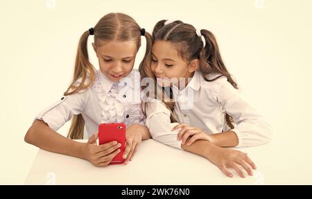 écoliers faisant selfie en classe. retour à l'école. filles enfants ayant le temps de selfie. amis de l'école blogeant et prenant selfie avec le téléphone Banque D'Images
