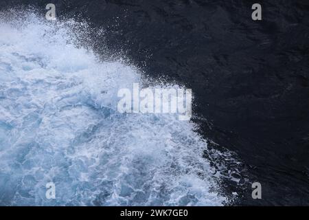 Vagues éclaboussant l'arc du navire dans les eaux de la mer de Chine méridionale, mousse sur l'eau et l'océan bleu foncé, Banque D'Images