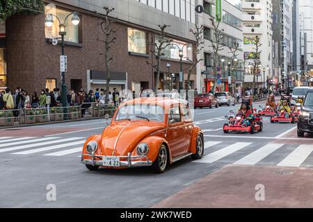 Shibuya, Tokyo, Orange VW volkswagon Beetle car mène des karts de rue sur la route à Shibuya, Japon, Asie, 2023 Banque D'Images