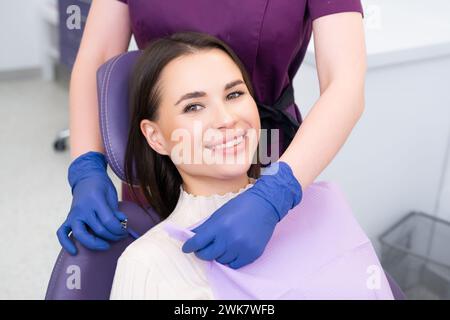 Belle femme brune ayant un traitement dentaire au cabinet du dentiste Banque D'Images
