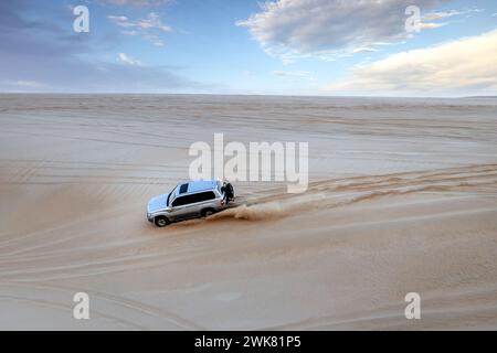 Une Toyota Land Cruiser grimpant la montagne du désert dans les dunes de sable de Sealine, Mesaieed, Qatar. Banque D'Images