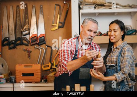 Artisans homme senior enseignant femme apprenti à Woodshop Banque D'Images