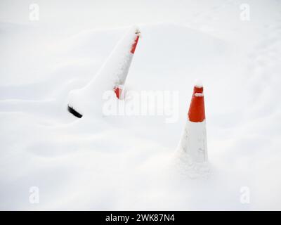 Cônes rouges de sécurité routière recouverts de neige Banque D'Images