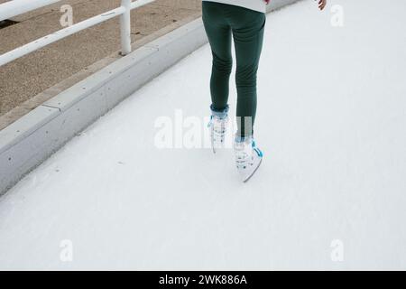 Les jambes des filles comme elle patine à glace en hiver sur le chemin sur les lames Banque D'Images