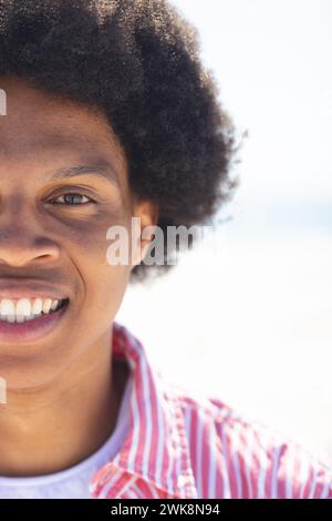 Un jeune homme afro-américain sourit brillamment dehors à la plage, inchangé Banque D'Images