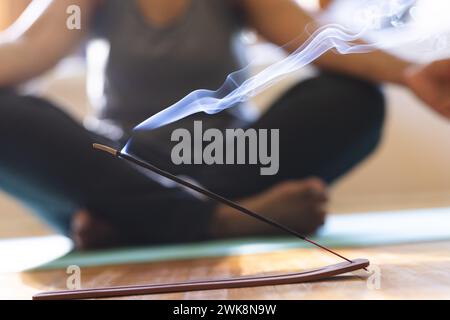 Gros plan de bâton d'encens brûlant pendant une séance de méditation à la maison Banque D'Images