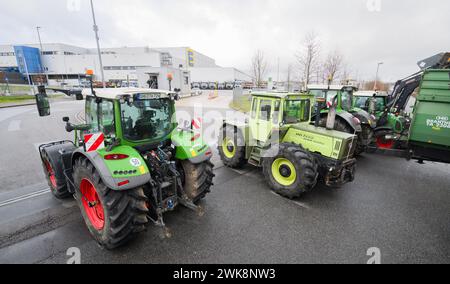 Lauenau, Allemagne. 19 février 2024. Les tracteurs bloquent une route d'accès à un entrepôt appartenant à la société de vente au détail Edeka près de l'autoroute A2 dans le quartier de Schaumburg. L’accès au site et à partir de celui-ci n’est pas possible, a déclaré une porte-parole du commissariat de police de Nienburg/Schaumburg. Près de 40 véhicules ont pris part au blocus. Crédit : Julian Stratenschulte/dpa/Alamy Live News Banque D'Images