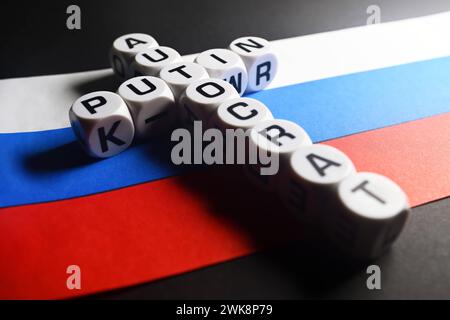 Buchstabenwürfel formen die Wörter Poutine und Autocrat engl. Dans Kreuzform auf russischer Fahne ***, les cubes de lettres forment les mots Poutine et Autocrat engl en forme de croix sur le drapeau russe Banque D'Images