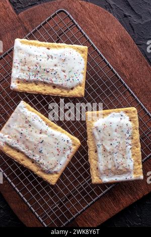 Sauter les tartes sur une grille de cuisson. Pâte grille-pain Poptart, tirée du haut sur une planche à découper en bois Banque D'Images