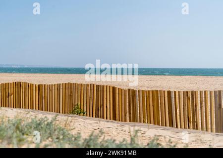 Plage de sable avec océan derrière, dune herbe de mer et clôture en bois Banque D'Images