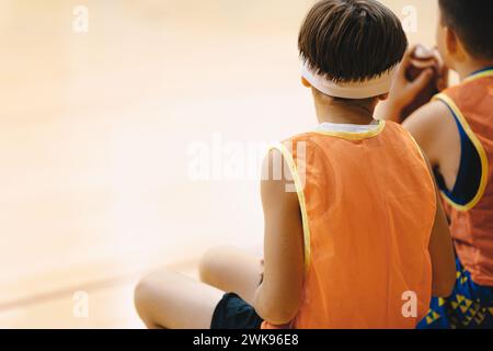 Basket-ball Boys reposant sur un banc de remplacement. Membres de l'équipe de l'école de basket-ball dans un match. Éducation sportive pour adolescents Banque D'Images