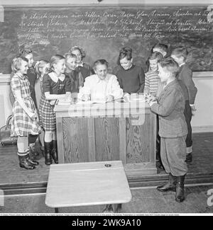 École dans les années 1950 La maîtresse d'école dans la salle de classe avec ses élèves, tous heureux et riant. Suède 1950 Kristoffersson ref BH11-11 *** local Caption *** © Classic Picture Library. Tous droits réservés. Protégé par une signature numérique. La surveillance et la protection de l'image sont activées sur cette image. La licence ; présentation ou newsletter N'inclut PAS l'utilisation sur les médias sociaux. Banque D'Images