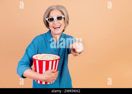 Photo de femme funky avec bob Hairdo chemise bleue habillée dans des lunettes 3d tenir pop-corn dirigeant à vous isolé sur fond de couleur pastel Banque D'Images