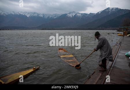 Srinagar, Inde. 19 février 2024. Un homme tire son bateau submergé pendant les rafales de vent et de pluie. Des rafales de vent ont endommagé plusieurs structures résidentielles à Srinagar. Dans un climat défavorable avec pluie et neige, les autorités ont émis un avertissement d'avalanche dans les parties supérieures du Jammu-et-Cachemire pour les 24 heures suivantes. Crédit : SOPA images Limited/Alamy Live News Banque D'Images