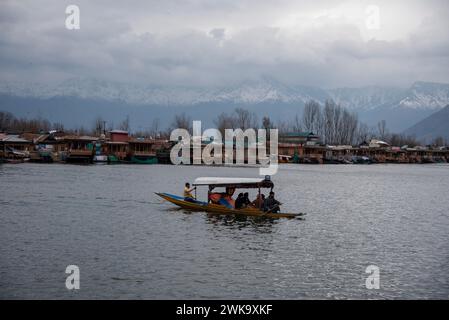 Srinagar, Inde. 19 février 2024. Un batelier de Shikara transporte des passagers au milieu de rafales de vent et de pluie. Des rafales de vent ont endommagé plusieurs structures résidentielles à Srinagar. Dans un climat défavorable avec pluie et neige, les autorités ont émis un avertissement d'avalanche dans les parties supérieures du Jammu-et-Cachemire pour les 24 heures suivantes. Crédit : SOPA images Limited/Alamy Live News Banque D'Images