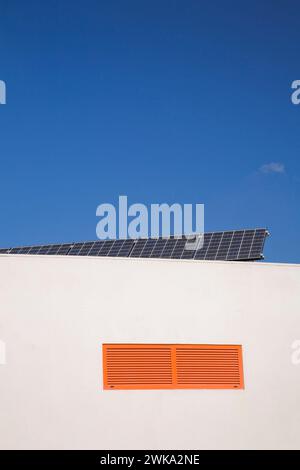 Panneaux de collecte d'énergie solaire sur le toit plat sur un bâtiment blanc, région de l'Algarve, Portugal. Banque D'Images