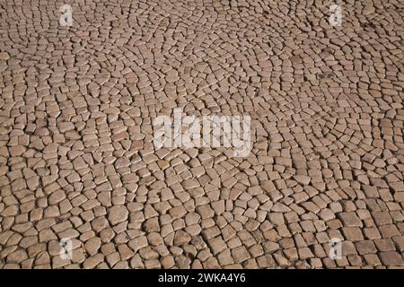 Motifs en pierre de mosaïque Tan sur une rue de la ville à Lisbonne, Portugal Banque D'Images
