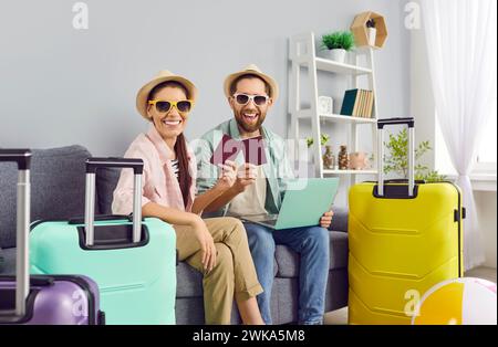 Couple joyeux avec passeports et valises emballées est prêt pour les vacances d'été tant attendues. Banque D'Images