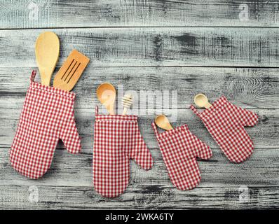 Moufles de cuisine et ustensiles de cuisine sur un fond en bois. Couverts sur fond de bois. Photo pour le menu. Le concept d'attente de nourriture. Maison COO Banque D'Images