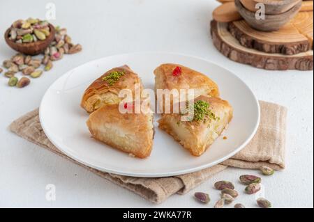 Trois pièces de baklava sur une plaque blanche avec pistaches et noix Banque D'Images