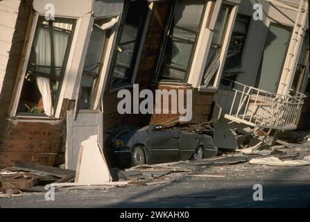 17 octobre 1989, San Francisco, Californie. Suite à un tremblement de terre de magnitude 6,9 qui a sévèrement secoué les régions de San Francisco et de Monterey Bay, une automobile se trouve écrasée sous le troisième étage de cet immeuble dans le Marina District. Les niveaux du sol ne sont plus visibles à cause de défaillances structurelles et de coulages dus à la liquéfaction. L'épicentre était situé près du pic Loma Prieta dans les montagnes de Santa Cruz. [J.K. Nakata, USGS] Banque D'Images