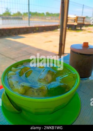 glace fraîche dans un bol avec jus de lime, noix de coco et tranches de melon. Banque D'Images