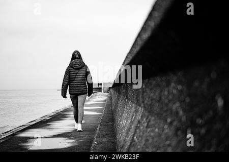 Marcher le long des défenses maritimes à Silloth, Cumbria, Angleterre, Royaume-Uni Banque D'Images