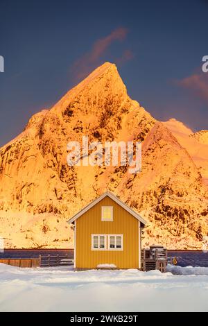 Îles Lofoten magnifique paysage de coucher de soleil nature en Norvège et ville de pêcheurs avec pittoresque maison de rorbu jaune de Sakrisoy, Reine Banque D'Images