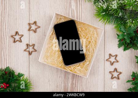 Achats de Noël en ligne. Maquette , smartphone à écran blanc sur fond de bois pour Noël et le concept du nouvel an, Flat Lay. vue de dessus, espace de copie. Banque D'Images