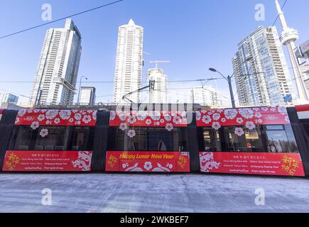 Toronto, Canada. 19 février 2024. Un tramway avec des dessins du nouvel an lunaire est vu à une gare de Toronto, Canada, le 19 février 2024. La Toronto transit Commission (TTC) a participé aux célébrations du nouvel an lunaire en transformant plusieurs de ses tramways et autobus avec des designs spéciaux. Crédit : Zou Zheng/Xinhua/Alamy Live News Banque D'Images