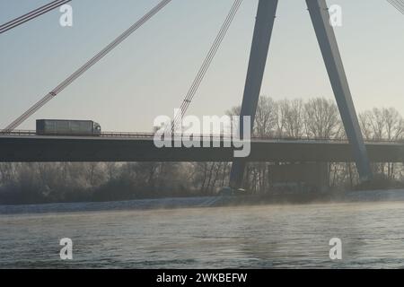 Guider un camion sur un pont animé tandis qu'un ferry glisse gracieusement le long du Rhin qui coule en contrebas. Banque D'Images