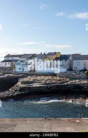 ville côtière aux maisons colorées perchées sur des falaises rocheuses, surplombant une mer calme sous un ciel clair Banque D'Images