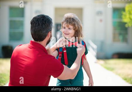 Père aidant le fils prêt à l'école. Le père soutient et motive son fils. Enfant allant à l'école primaire. Banque D'Images