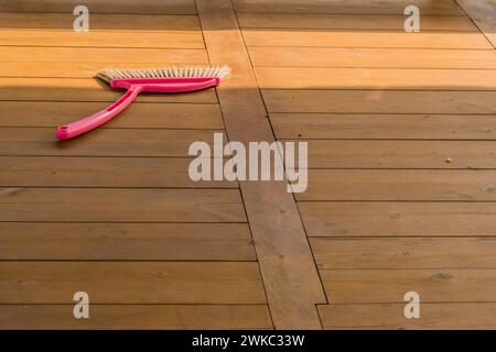 Balai en plastique rouge posé sur une table de pique-nique en bois dans un parc public en Corée du Sud Banque D'Images