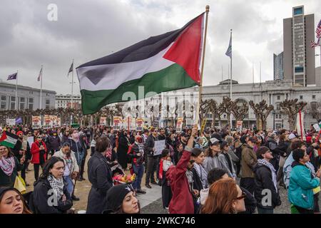 San Francisco, États-Unis. 19 février 2024. Les manifestants se rassemblent devant la mairie avec des pancartes et des drapeaux. Des milliers de manifestants pro-palestiniens se sont rassemblés pour une marche à San Francisco, coïncidant avec la journée du président des États-Unis. Leurs principales revendications comprenaient un cessez-le-feu dans la région de Gaza et la cessation de l'aide à Israël de la part de l'administration Biden. Crédit : SOPA images Limited/Alamy Live News Banque D'Images
