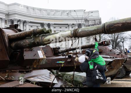 Kiev, Ukraine. 14 février 2024. Une femme et son enfant regardent les chars russes détruits exposés dans le centre de Kiev. Les troupes russes sont entrées sur le territoire ukrainien le 24 février 2022, déclenchant un conflit qui a provoqué des destructions et une crise humanitaire. Crédit : SOPA images Limited/Alamy Live News Banque D'Images